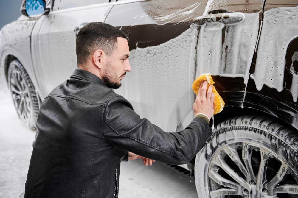 Muž ručně myjící auto